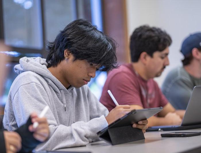 Student taking notes in a classroom